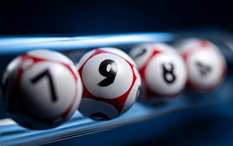 Cinco bolillas numeradas del Loto 5 Plus en el tubo